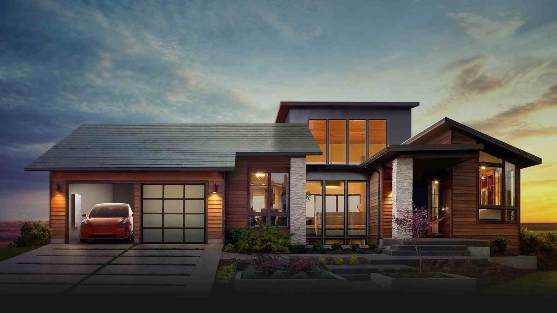 Esterno di una casa di design dove nel garage si vede la batteria di accumulo fotovoltaico Tesla